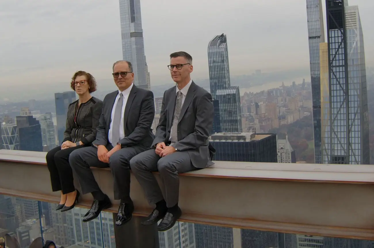Stonberg, Hickman & Pavloff attorneys seated on a Manhattan skyline ledge